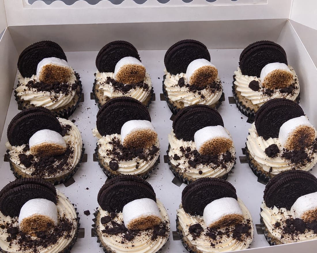 A boxed dozen cupcakes, piped and decorated